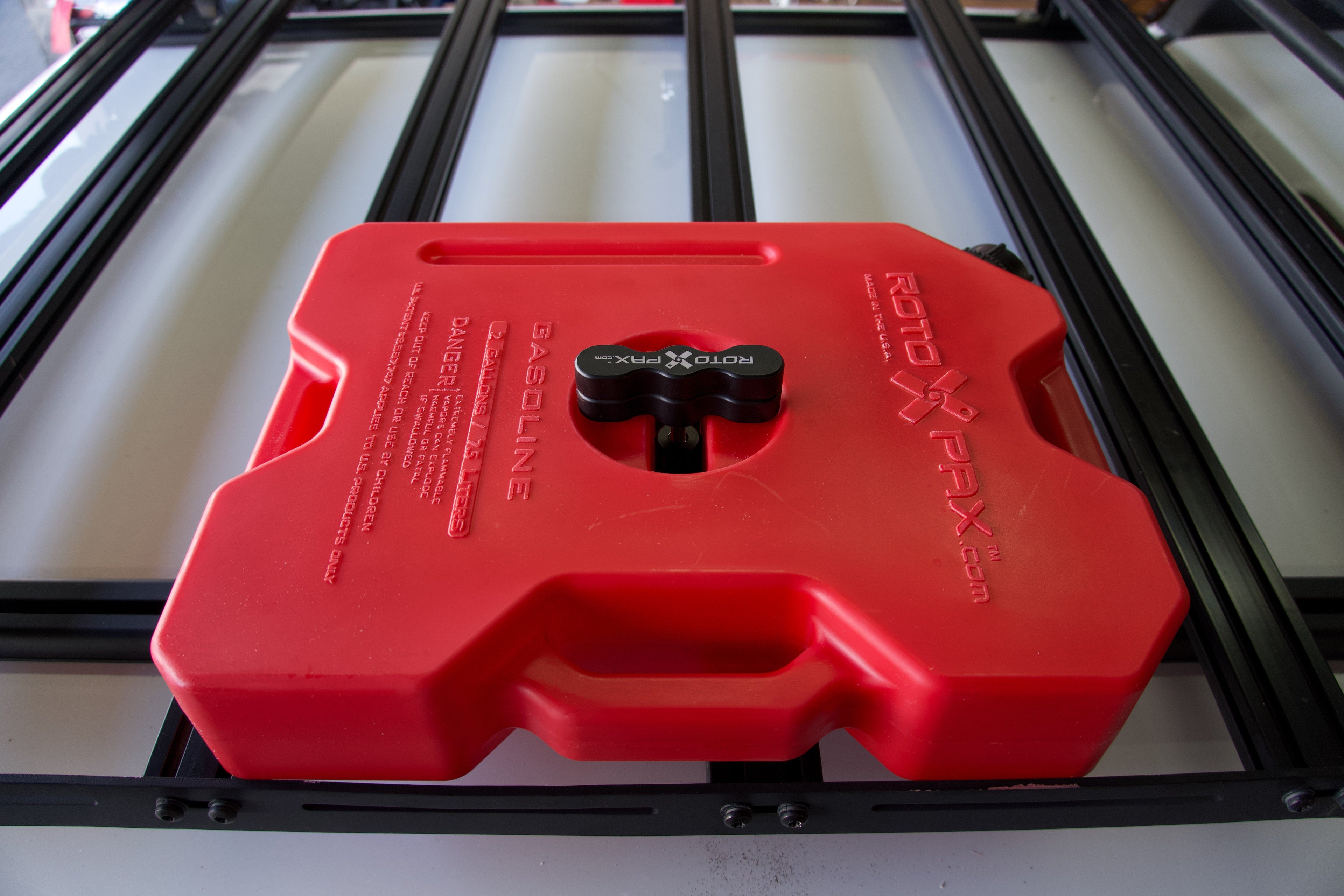 Billet aluminum Rotopax mount adapter for extrusion roof rack cross bars.
